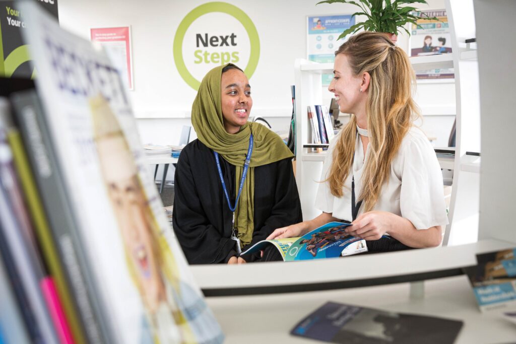 A female college learner sat with a female member of staff