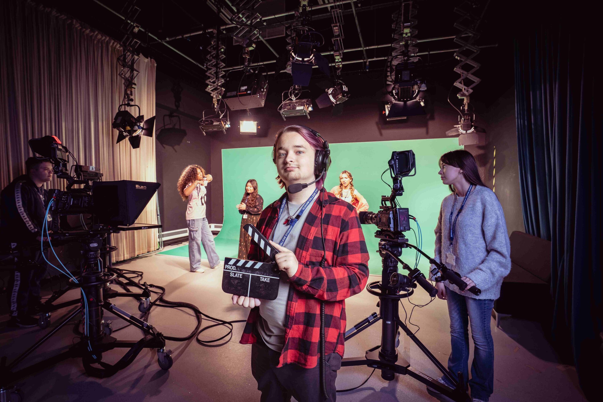 Male media student in a mock tv studio with green screen