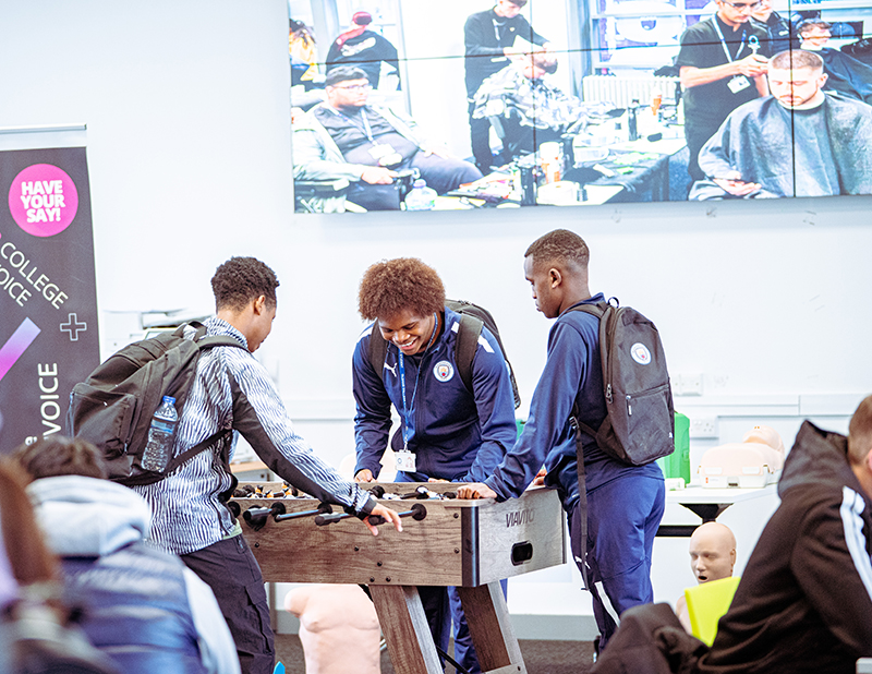 Three male college students playing fusball