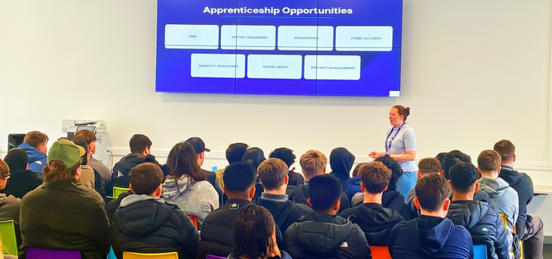A classroom of students watch an apprenticeships presentation delivered on a big screen.